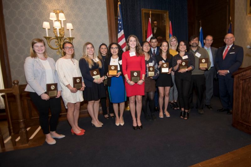 Large group photo of Pan American Day 2019 attendees and honorees with international flags in elegant venue.